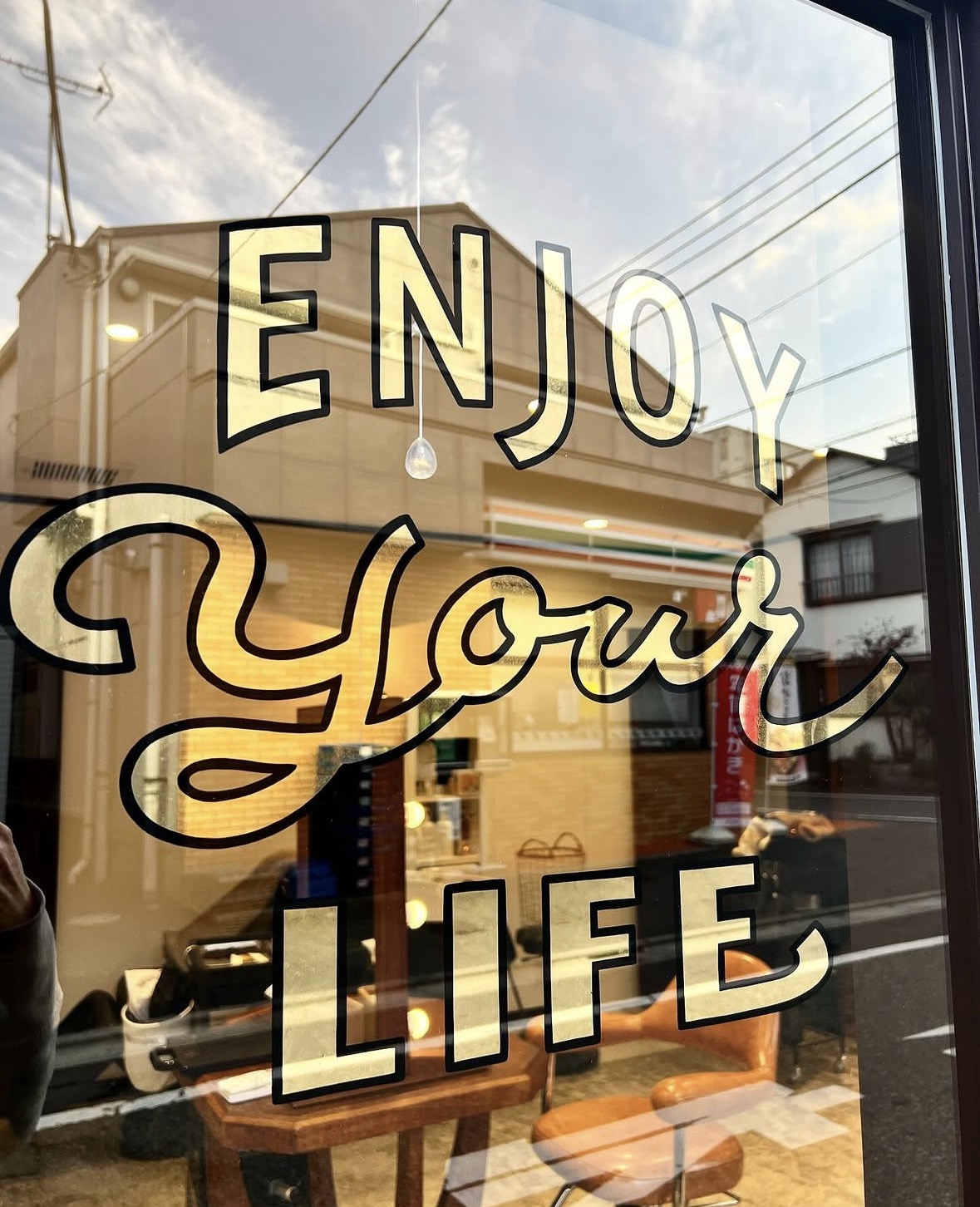 サロンの窓に描かれた「ENJOY YOUR LIFE」のロゴ